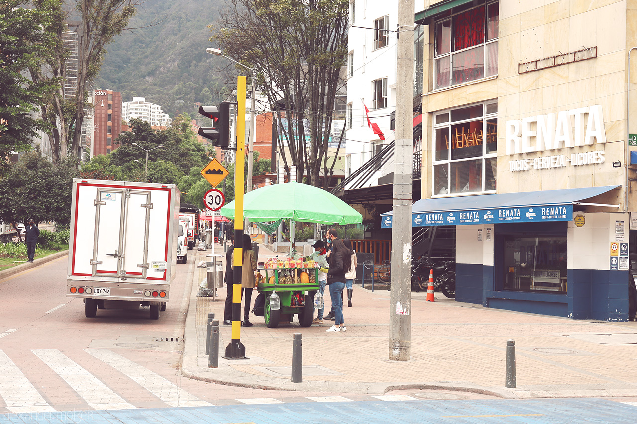 Foto von Street vendor under green umbrella, everyday life in Chapinero district, with Andes backdrop.