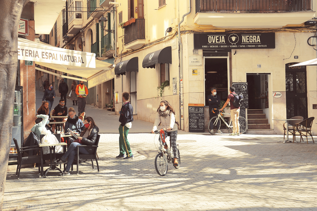 Foto von An urban scene in Palma, with locals basking in the Mediterranean sun amidst charming cafés and rustic streets.