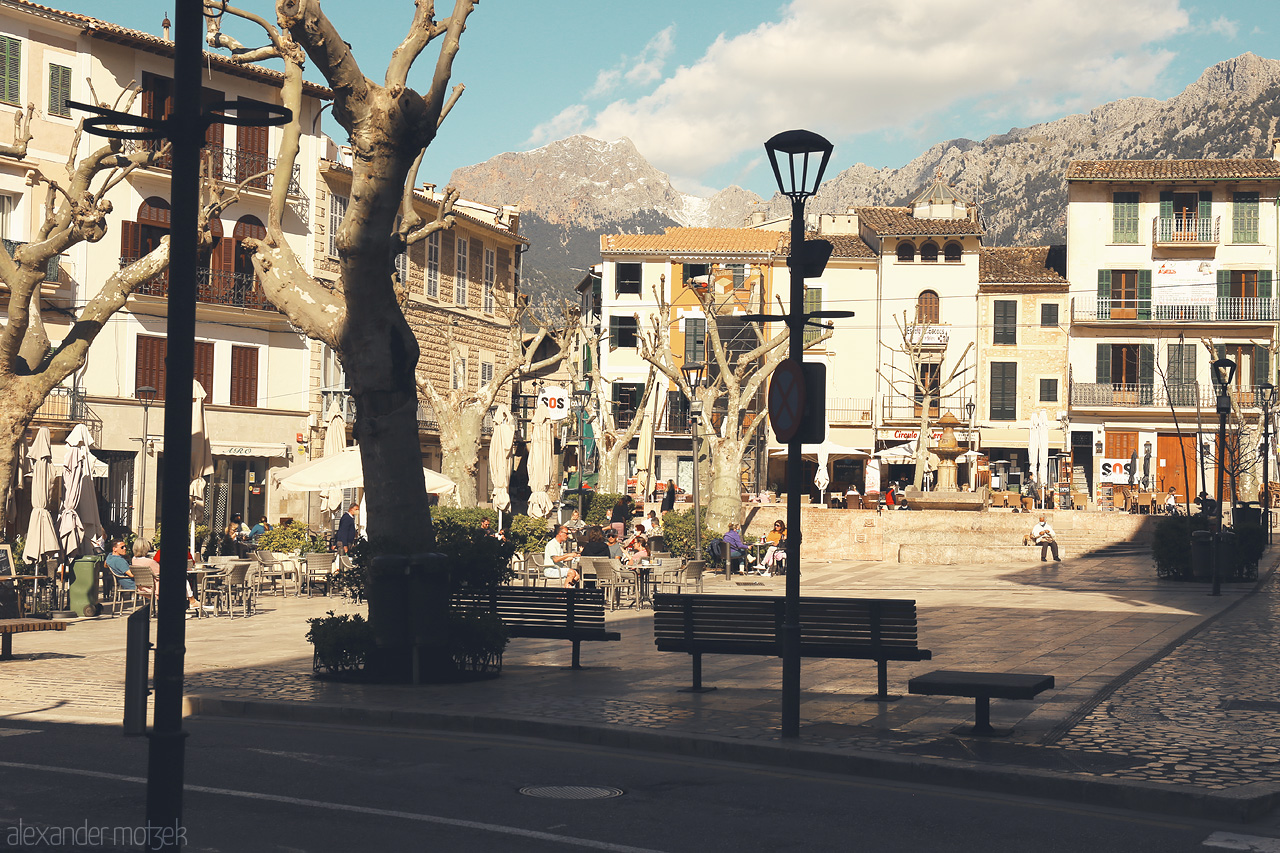 Foto von Café-lined plaza in Sóller under the Tramuntana, with locals soaking up the tranquil Mallorcan vibe.