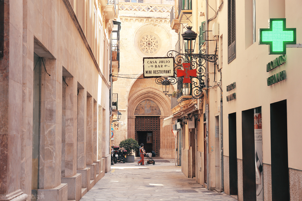 Foto von Charming cobblestone streets of Palma, with the Gothic architecture peeking in the sun-drenched alley.
