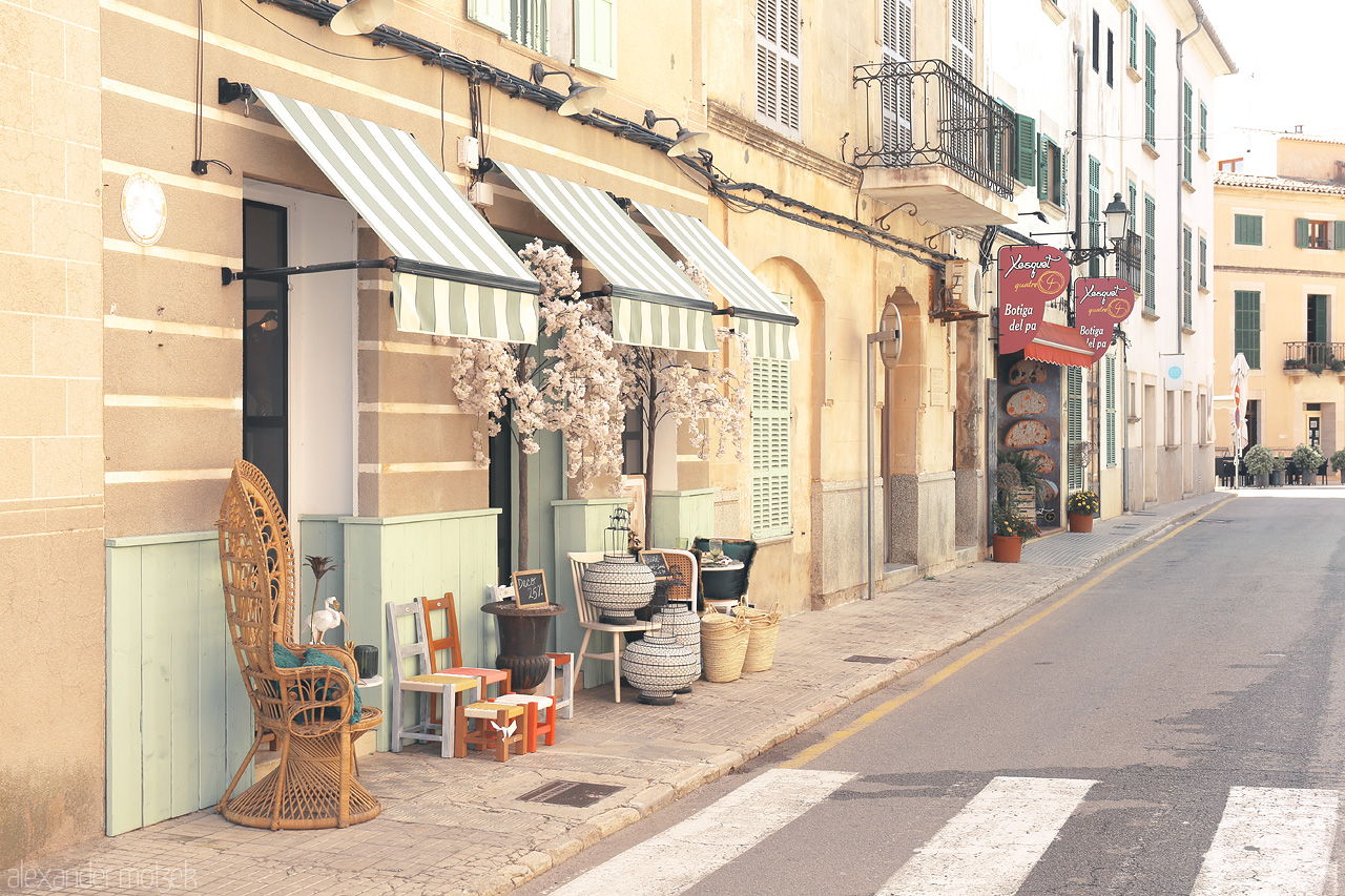 Foto von Quaint Ses Salines street scene with blossoms adorning a picturesque shopfront under the soft Balearic sun.