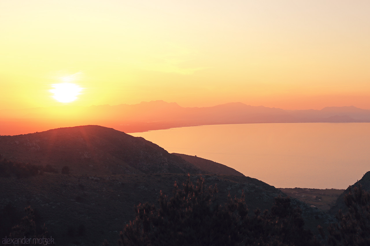 Foto von Sunset draping Artà's hills in a warm glow, overlooking the calm Mediterranean Sea in Mallorca, Spain.