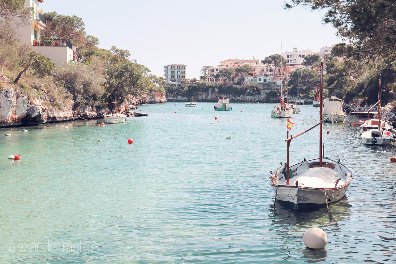 Foto von Tranquil waters cradle boats in Cala Figuera, a serene Mallorcan harbor wrapped in nature's embrace.