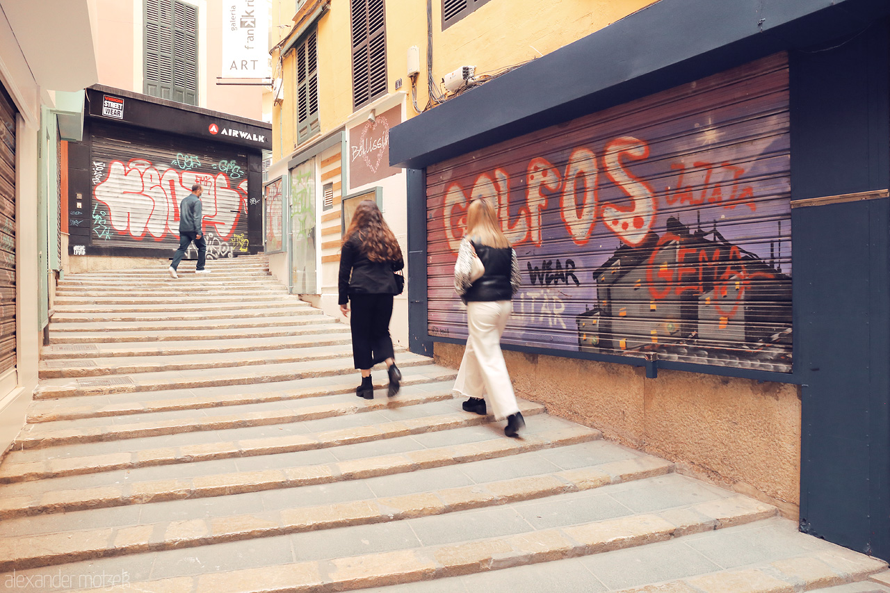 Foto von Two figures ascending the urban stairway, with the vibrant art of Palma's streets as their backdrop.