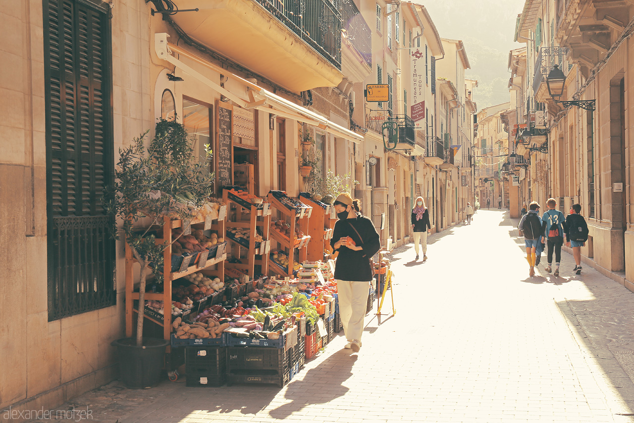 Foto von Warm sunlight bathes Sóller's vibrant street, a harmonious blend of bustling life and quaint island charm.