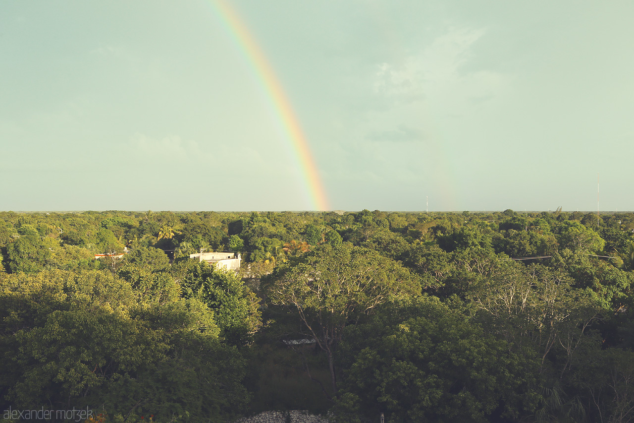 Foto von A vibrant rainbow arcs over the lush greenery of Izamal, Yucatán, embracing the serene landscape.