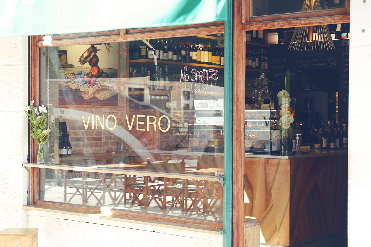 Foto von A cozy Venetian wine bar, VINO VERO, glimpsed through an inviting window, embodying the spirit of Venice.