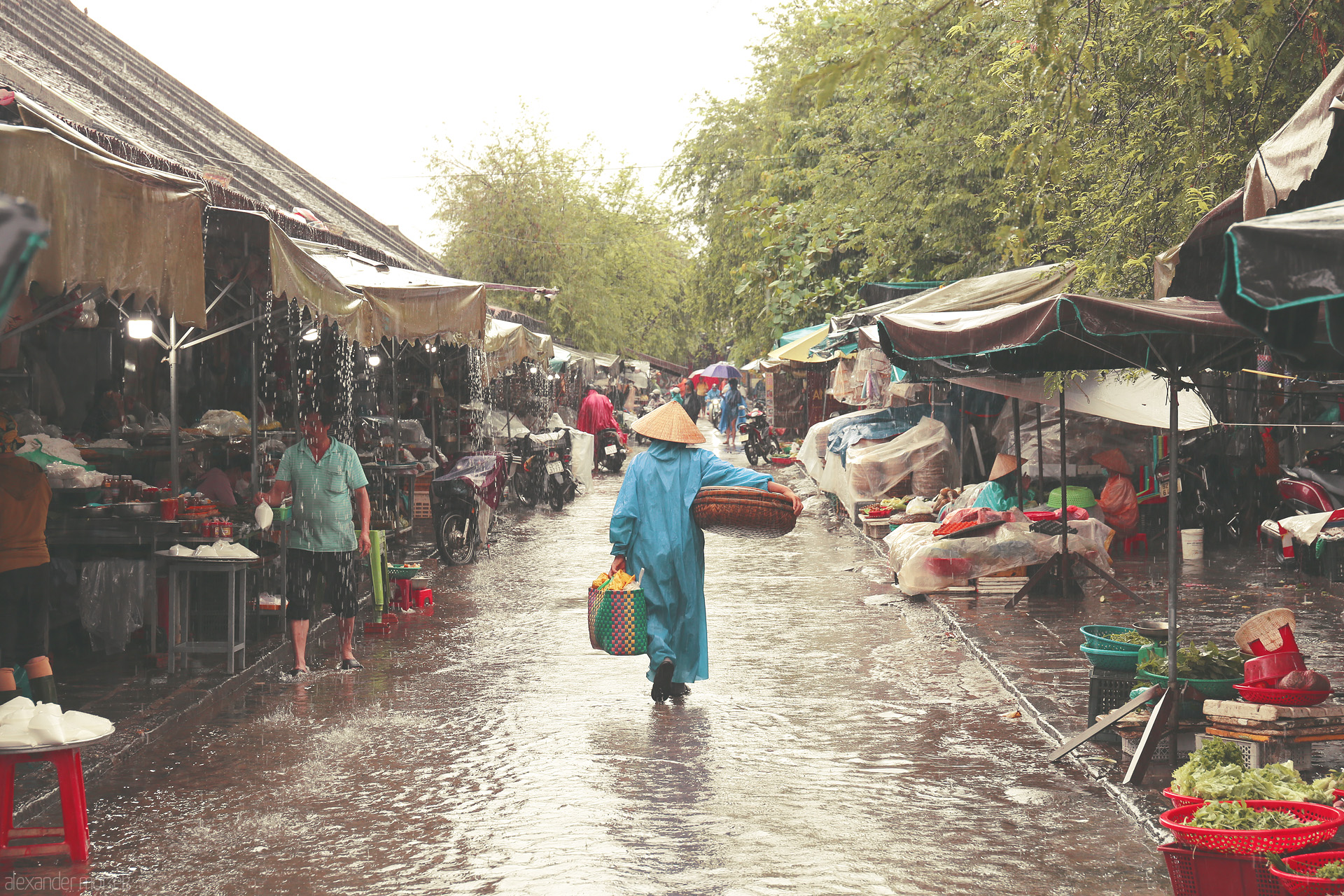 Foto von A Hoi An market scene, rain-drenched and vibrant, where life weaves through puddles and conical hats under the Vietnamese monsoon.