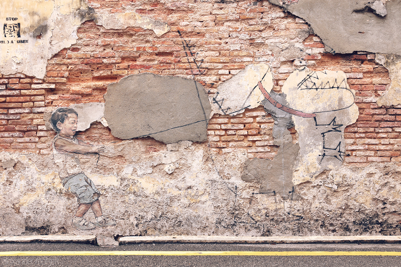 Heritage Canvas Foto von A playful mural in Penang captures a child pulling on a prehistoric creature. A blend of art and heritage on weathered walls.