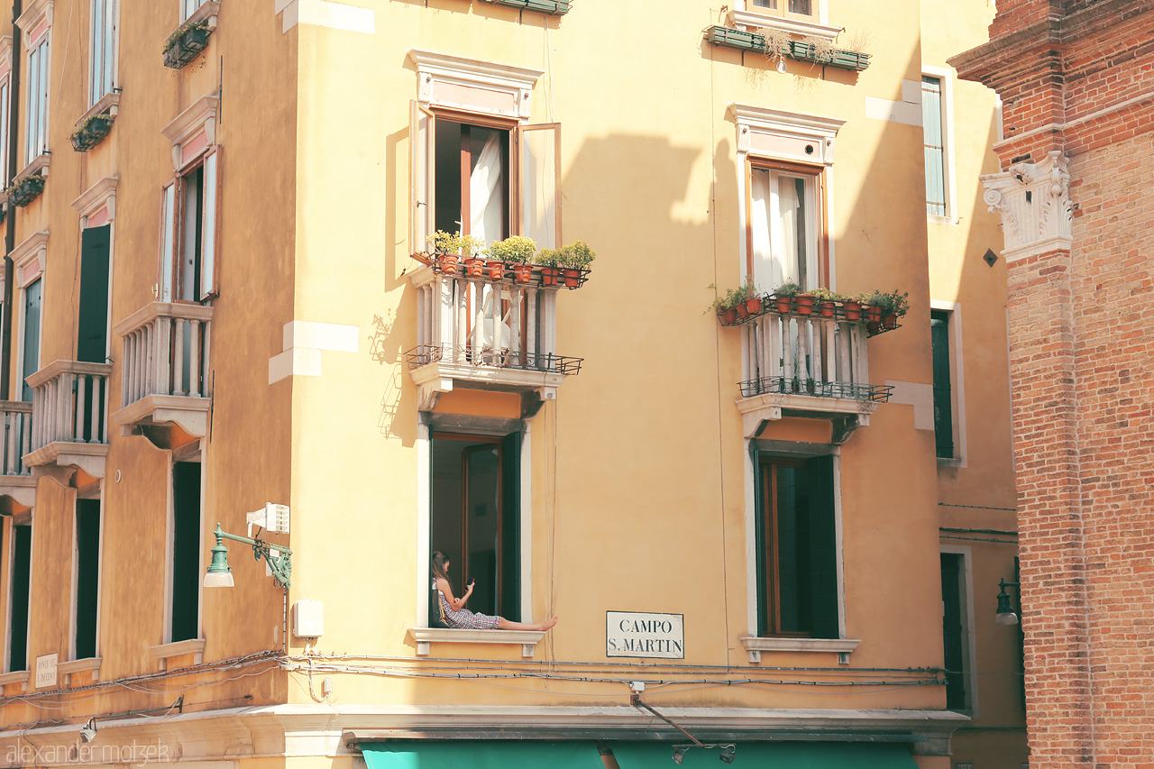 Balconi di Burano Foto von A quaint balcony amidst Venetian hues, framed by history and bathed in the warm Italian sun.
