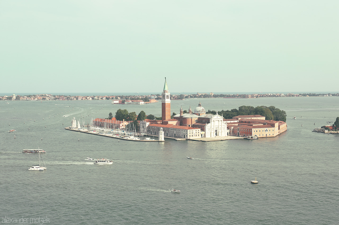 Venetian Vistas Foto von A serene aerial view of Venice's iconic waterscapes, boats gliding over the lagoon alongside historic architecture.