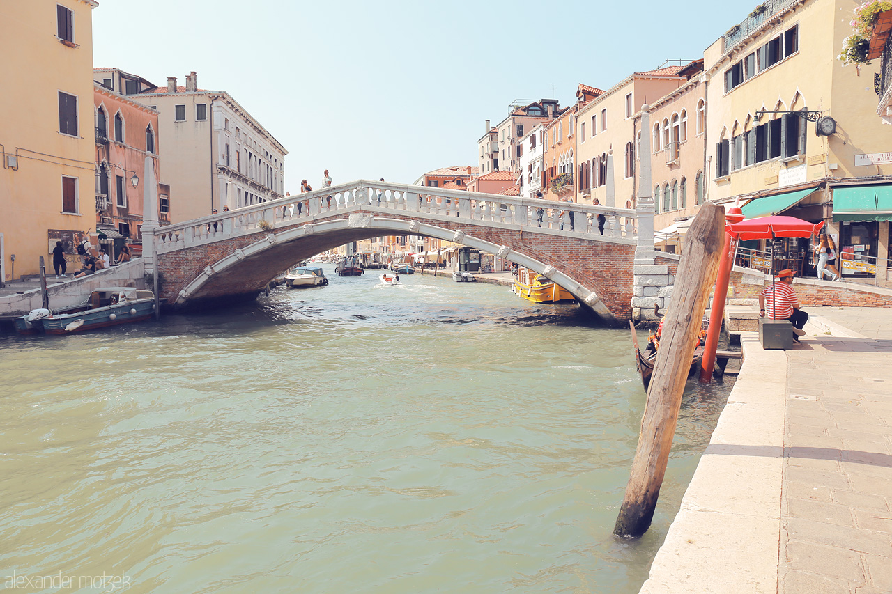 Ponte Perspectiva Foto von A serene canal view in Venice with a classic bridge, gondolas, and vibrant local life.