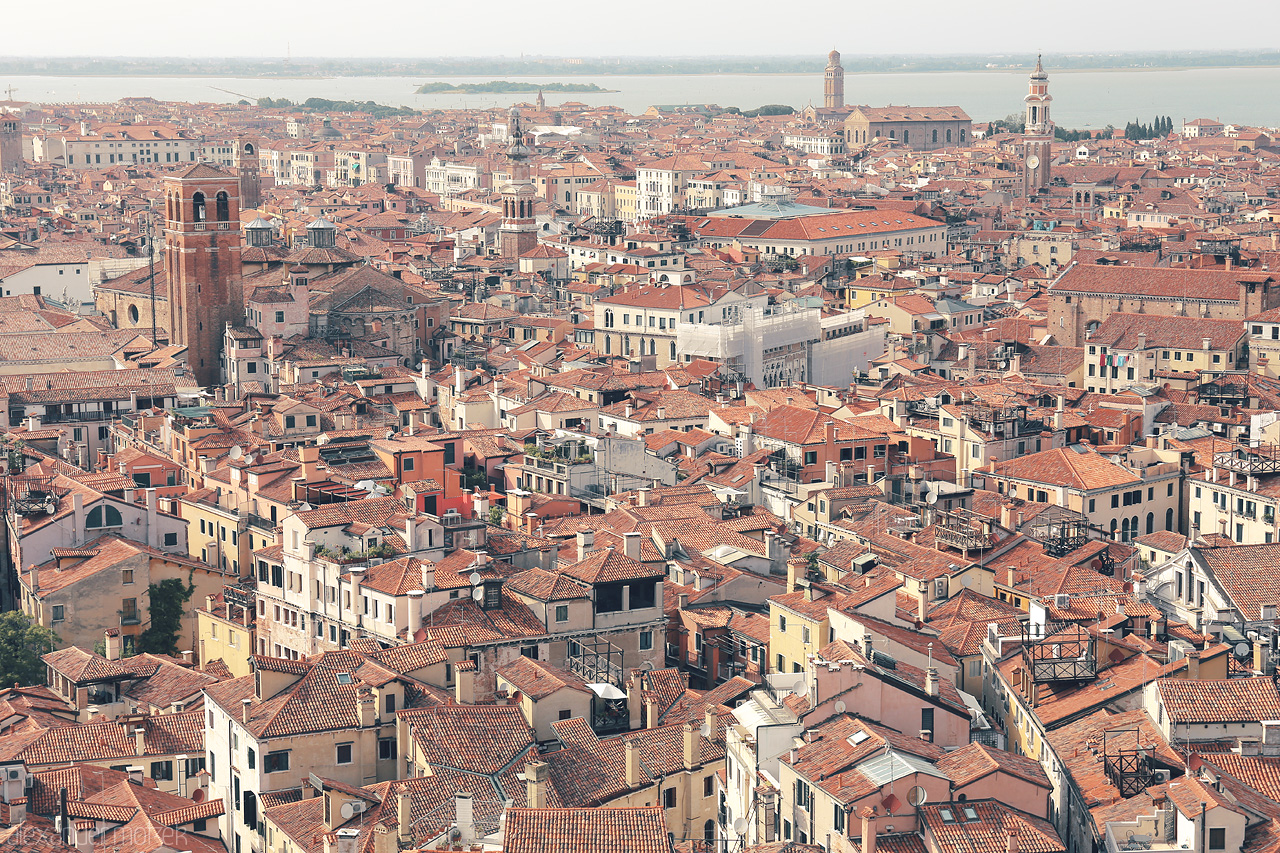 Terracotta Hues Foto von A sun-kissed expanse of Venetian rooftops, bell towers piercing the skyline, and the lagoon's shimmer in the distance.