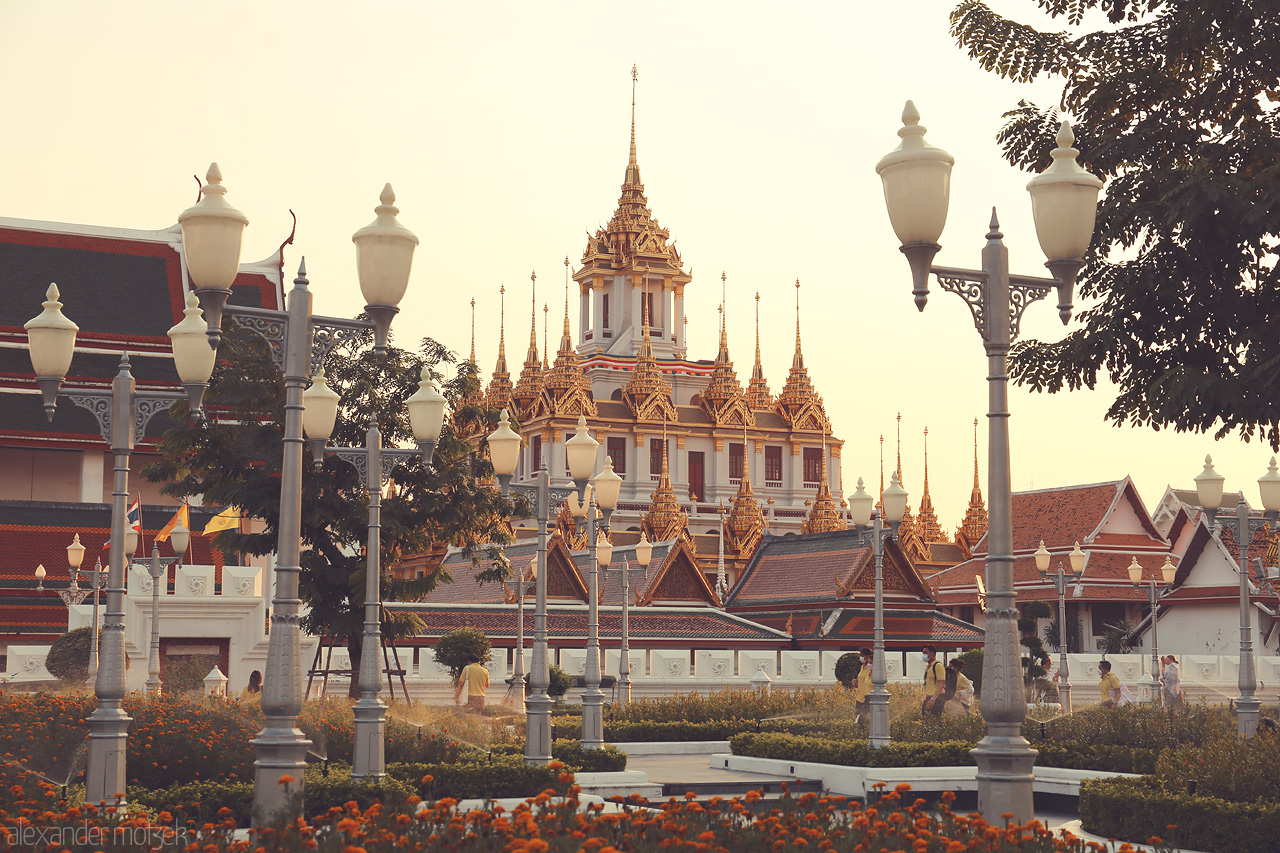 Dusit Dreams Foto von A tranquil evening at Ban Phan Thom, Bangkok, with golden spires and serene gardens, capturing the essence of Thai elegance and peace.