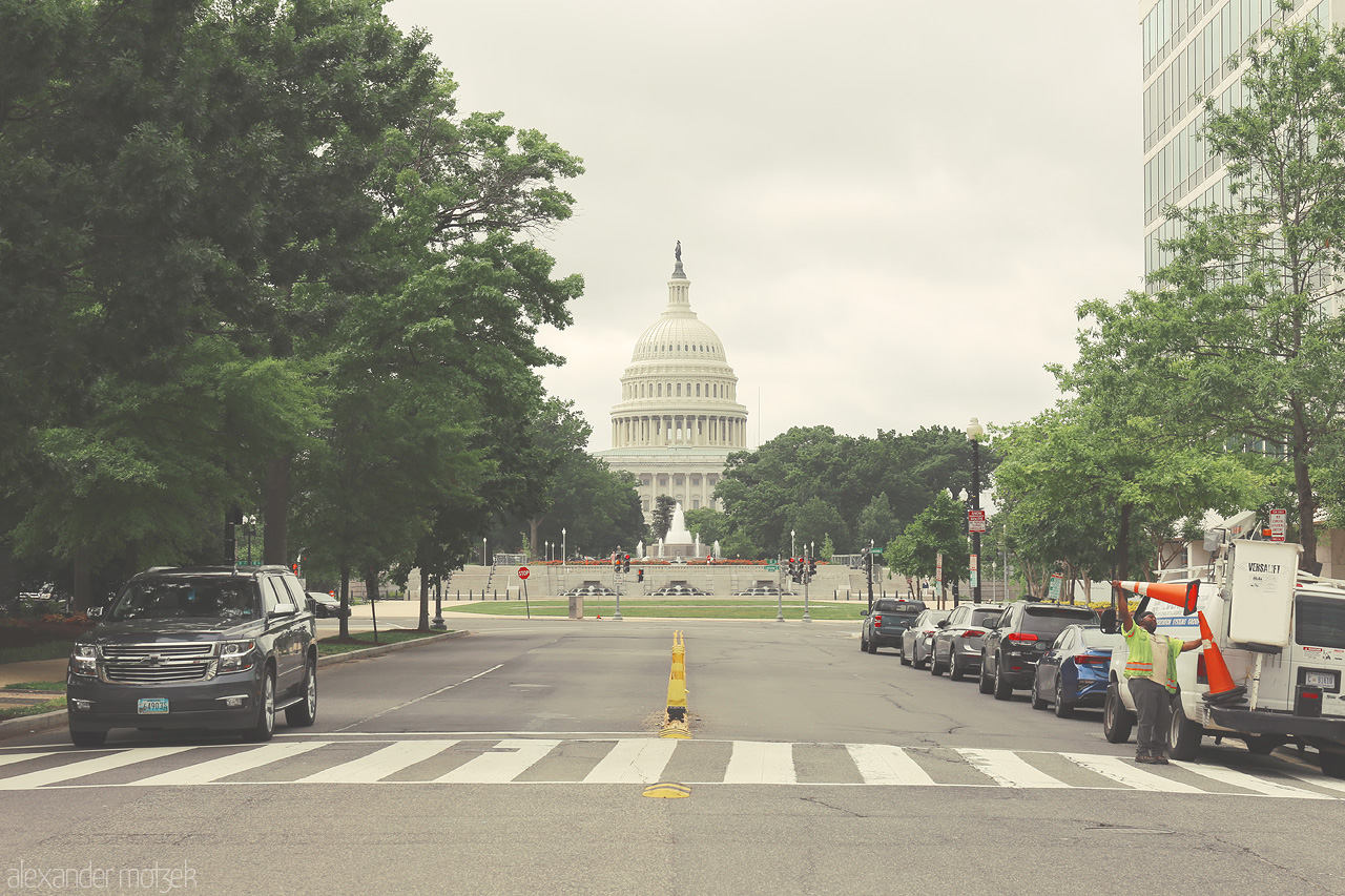 Capitol Cloudscape Foto von A tranquil view of the U.S. Capitol amidst lush greenery and urban life in Washington D.C.