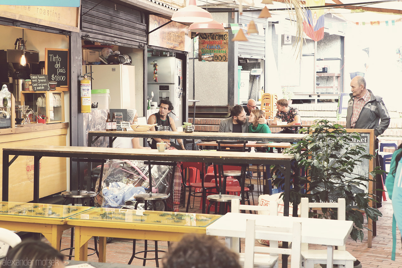Tinto del país Foto von A vibrant moment at a cozy café in La Candelaria, Bogota, capturing everyday life and local charm. Amor en el andén y sabor colombiano.
