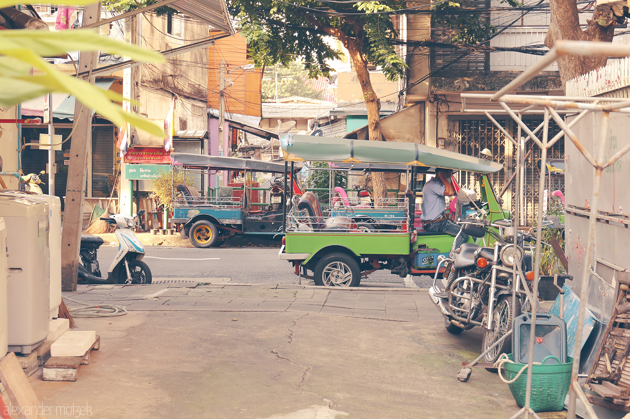 Serenity in Soi Foto von A vivid street scene in Khlong Maha Nak, Bangkok, capturing tuk-tuks and local life under dappled sunlight.