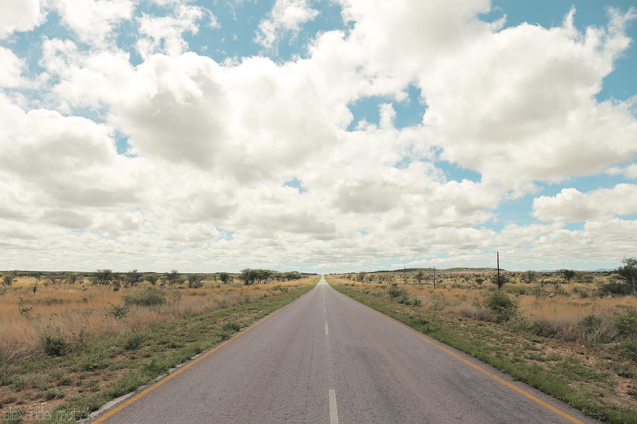 Otjozondjupa's Endless Path Foto von An open road stretches into the horizon under a cloud-draped sky in Otjozondjupa, Namibia.