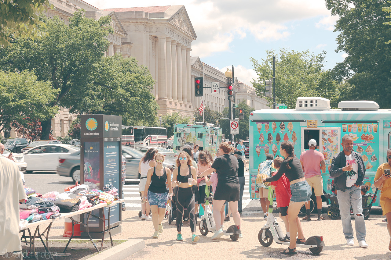 Scooters & Sunlight Foto von Bustling scene of pedestrians and street vendors near iconic buildings in Washington, D.C., the heart of American history.