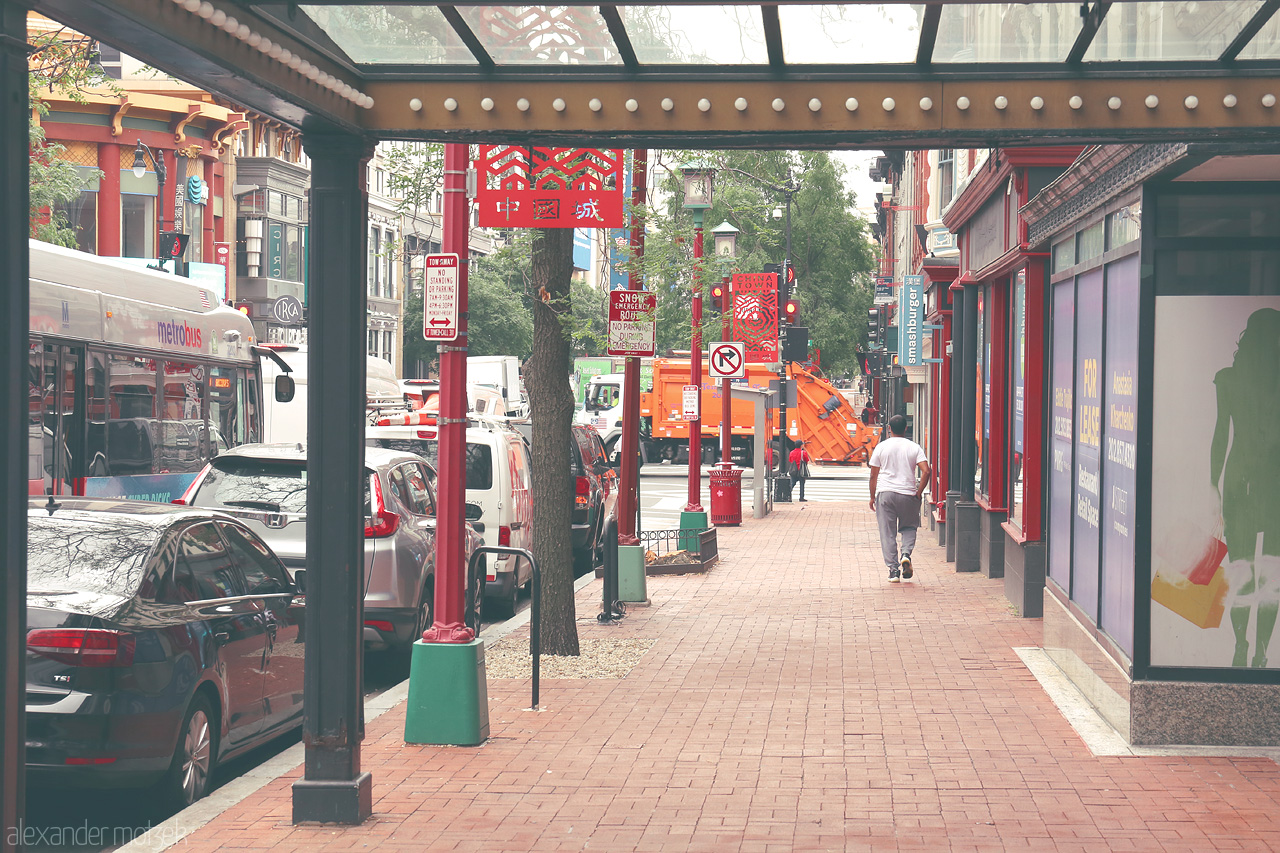 Capital Vibes Unveiled Foto von Bustling streets of DC's Chinatown, where urban life meets cultural charm under vibrant signs and lined walkways.