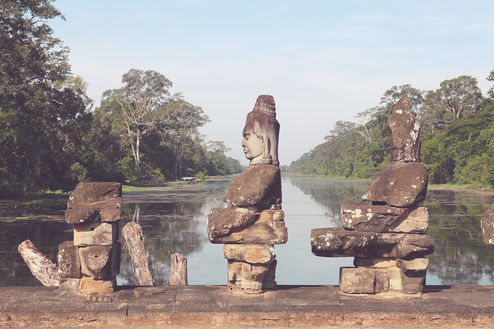 Serenity of Devata Foto von Ancient stone guardians gaze serenely over the water at Angkor Wat, Siem Reap, Cambodia, surrounded by lush jungle and tranquil reflection.