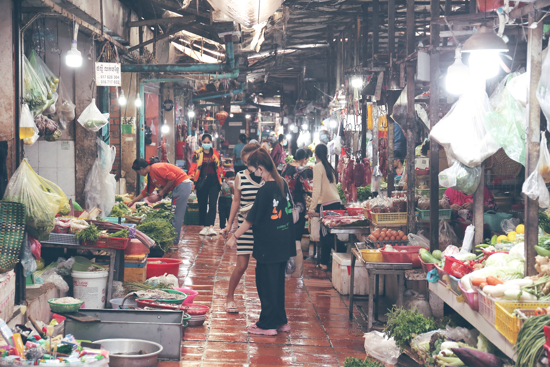 Phsar Life Mosaic Foto von Bustling vendors and locals line the vibrant, rain-washed aisles of a Phnom Penh market, bursting with fresh produce and Khmer energy.