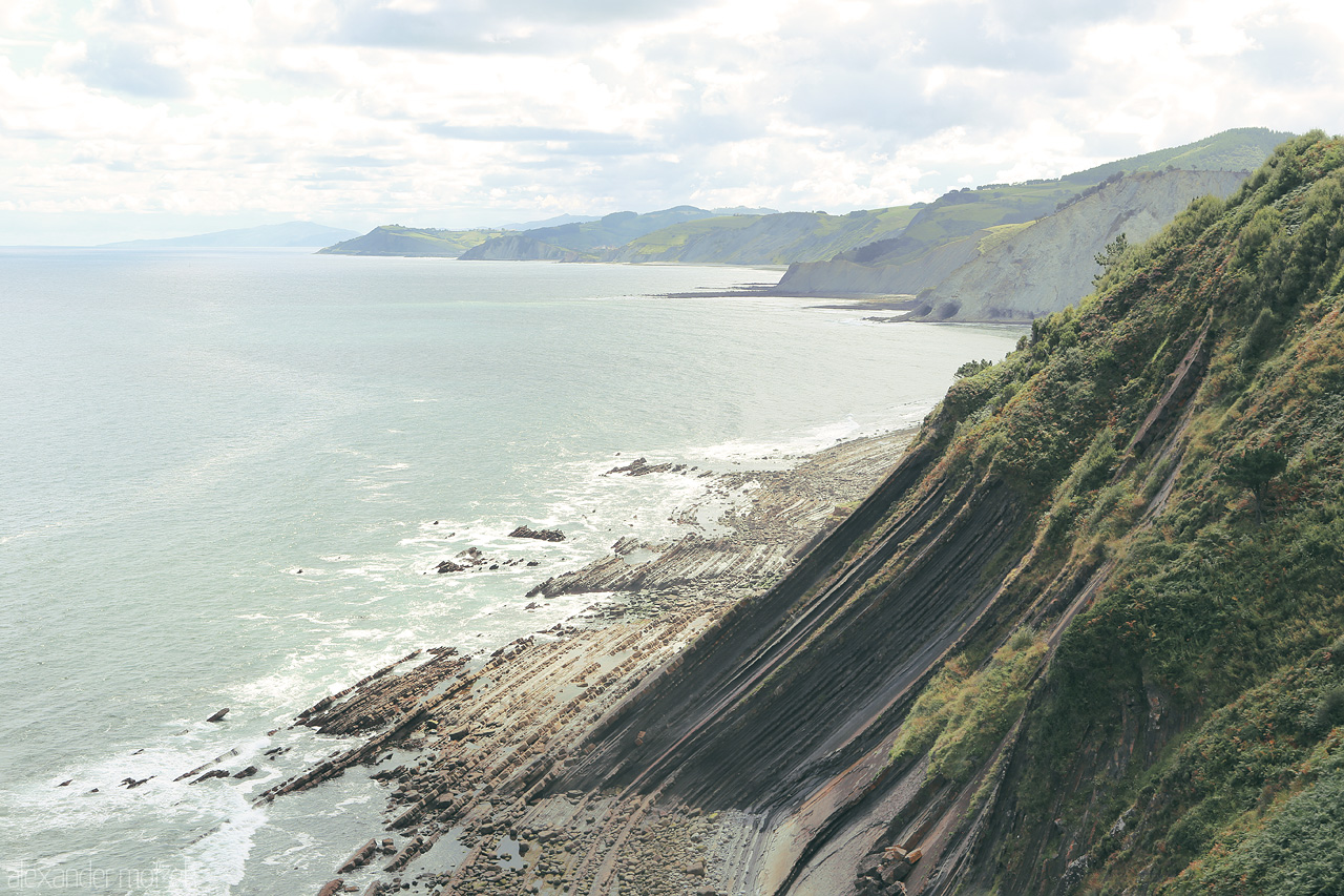 Euskal Flysch Foto von Capturing the serene Basque coast in Deba, with striated cliffs descending into the Bay of Biscay.