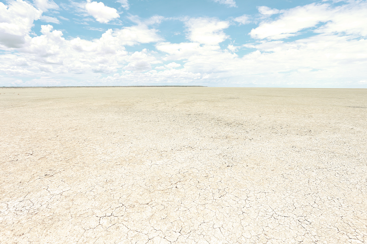 Omajowa's Canvas Foto von Cracked earth stretches under a vast sky in Etosha, Namibia, evoking the wild's stark beauty.