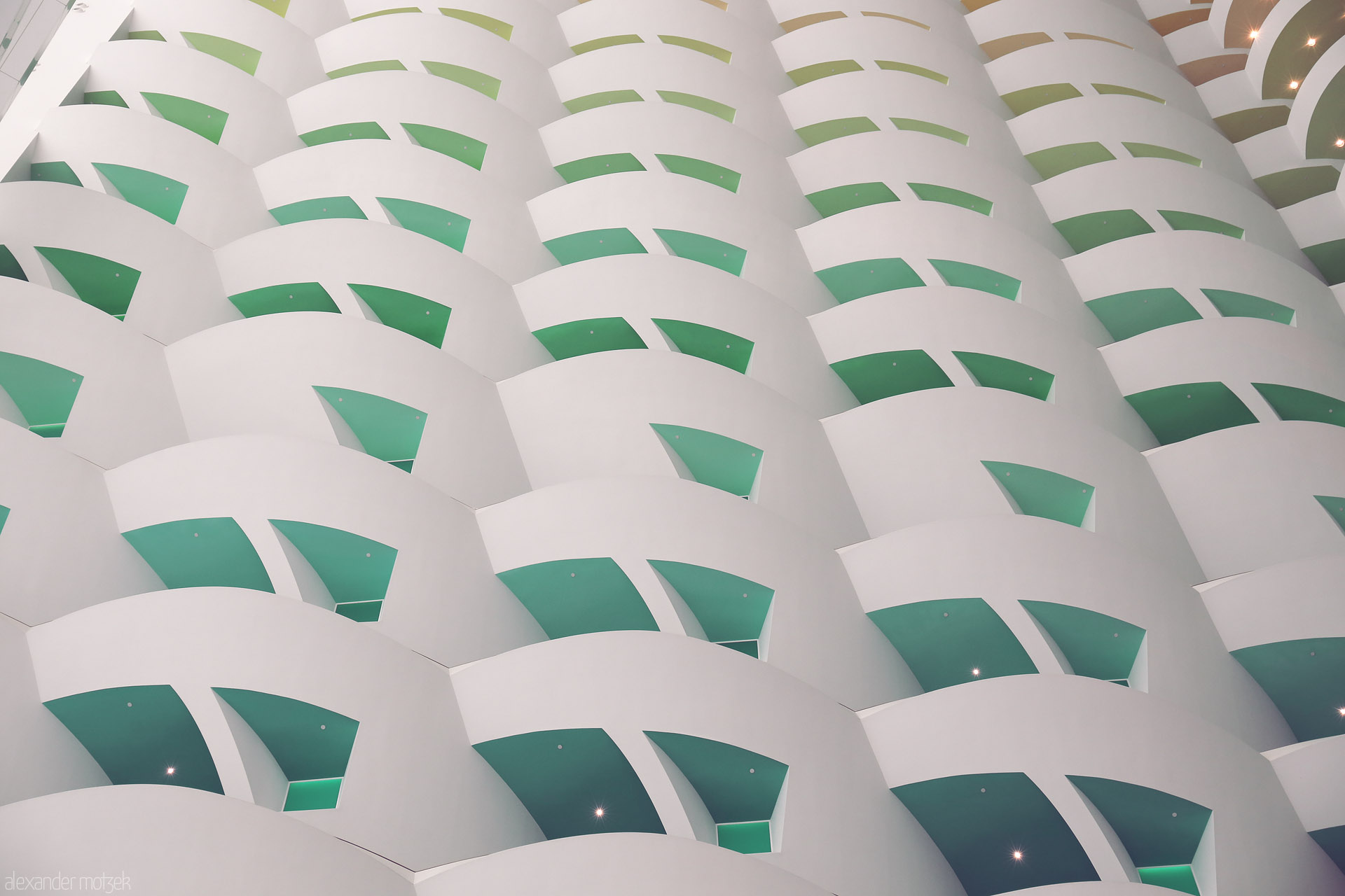 Emerald Arches Foto von Curved white balconies with green reveals mimic waves—modern Dubai architecture echoing desert tradition, United Arab Emirates.