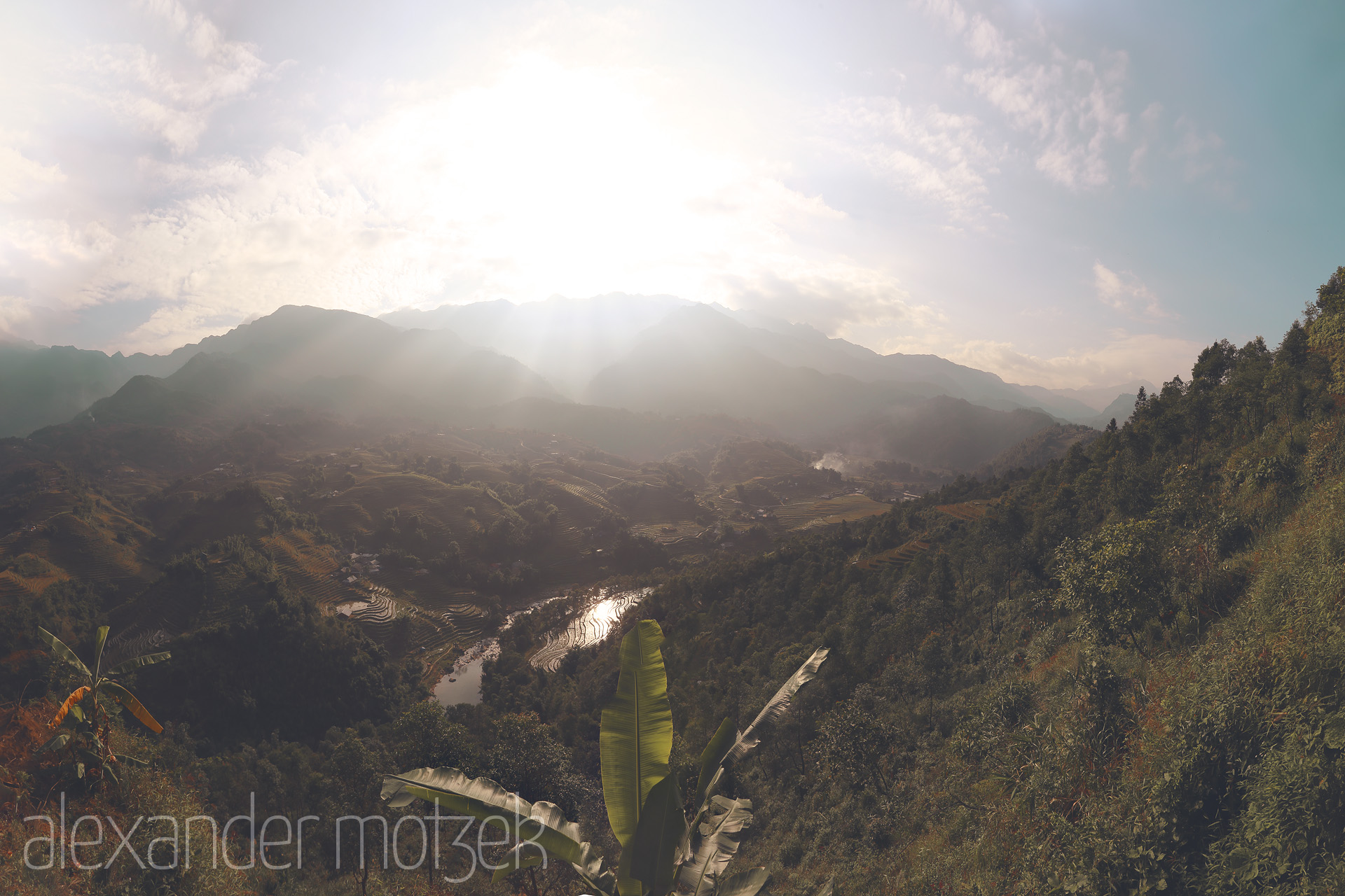 Foto von Dawn spills over Sapa's terraced valleys, reflecting in the winding river as mist floats above lush Vietnamese highlands.