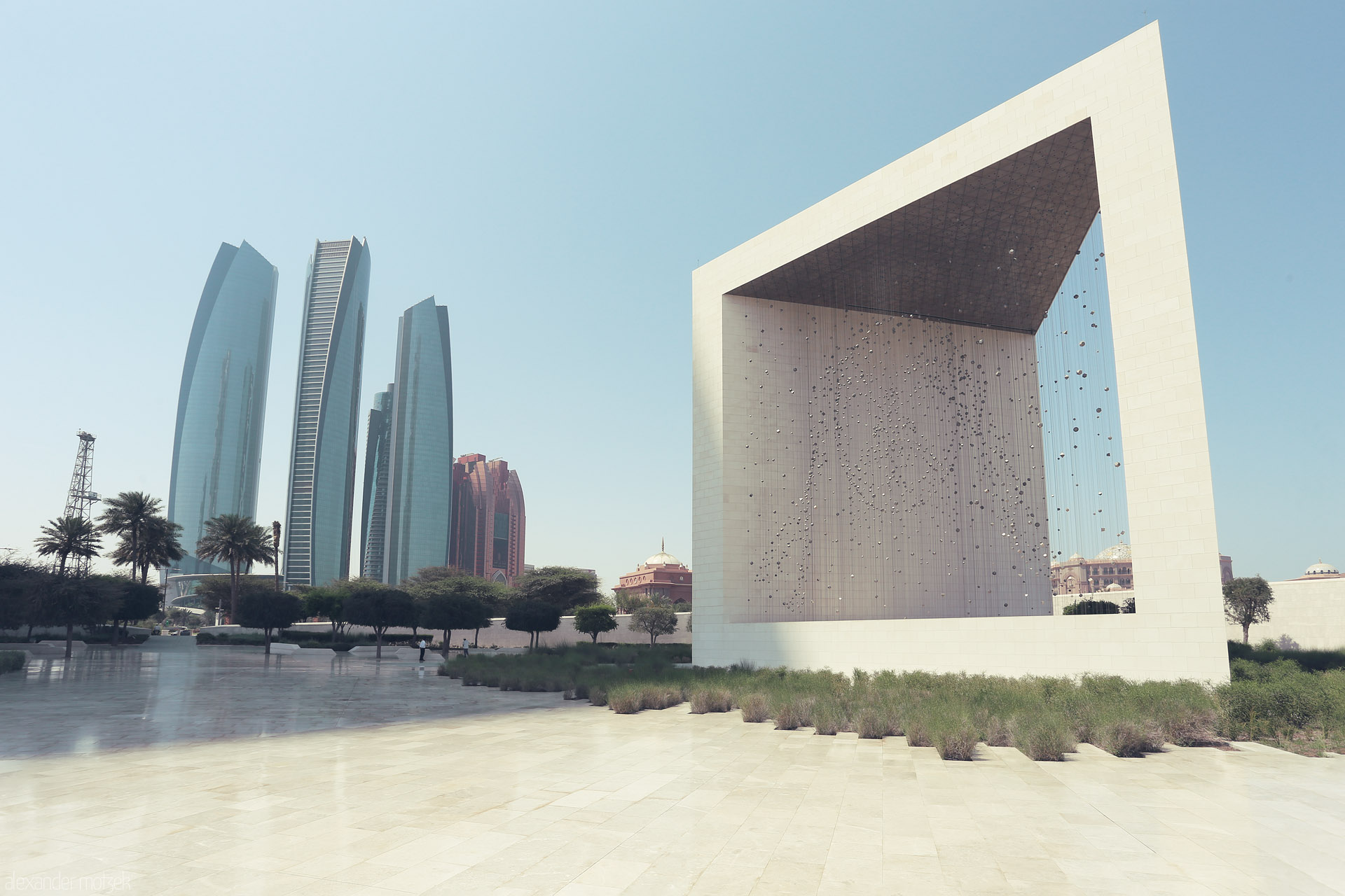 Naqsh of Al Ras Foto von Etihad Towers rise behind the sculptural Wahat Al Karama in Al Ras Al Akhdar, Abu Dhabi—modern marvels in calm desert light.