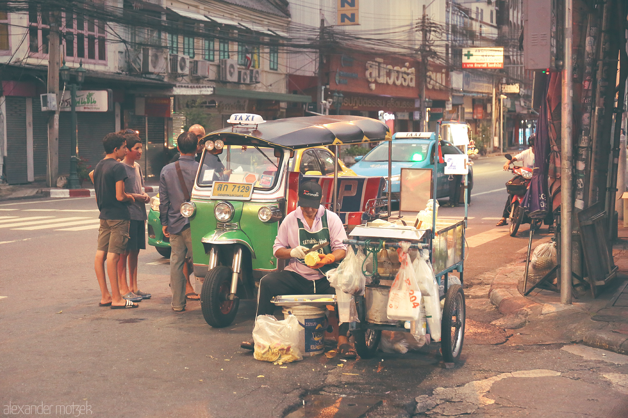 Twilight Tuk-Tuk Tales Foto von Evening falls on Talat Yot, Bangkok, where the bustling street life and a colorful tuk-tuk reflect the city's vibrant charm.
