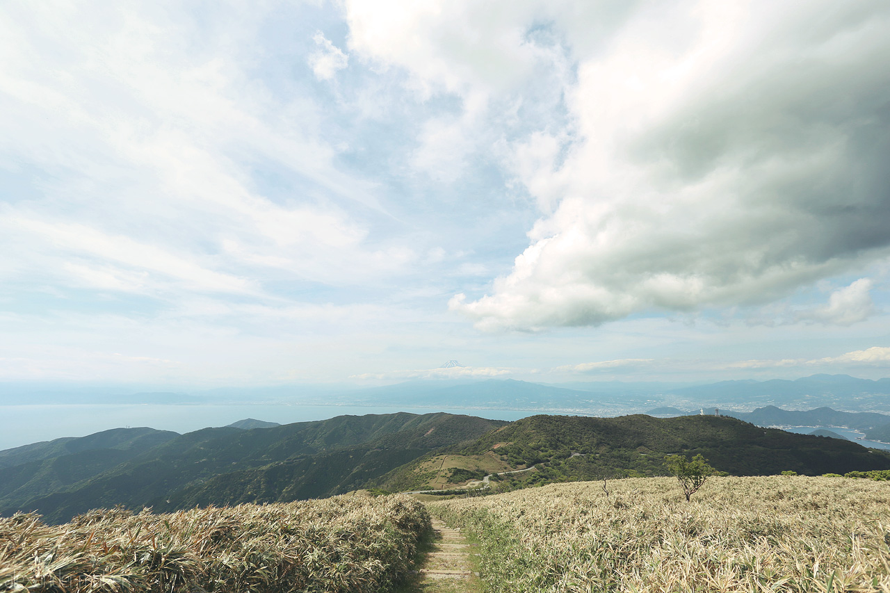 Pathways to Fuji Foto von Gaze over Izu’s lush trails with Mount Fuji on the horizon under a vast, cloudy sky in Shizuoka, Japan.