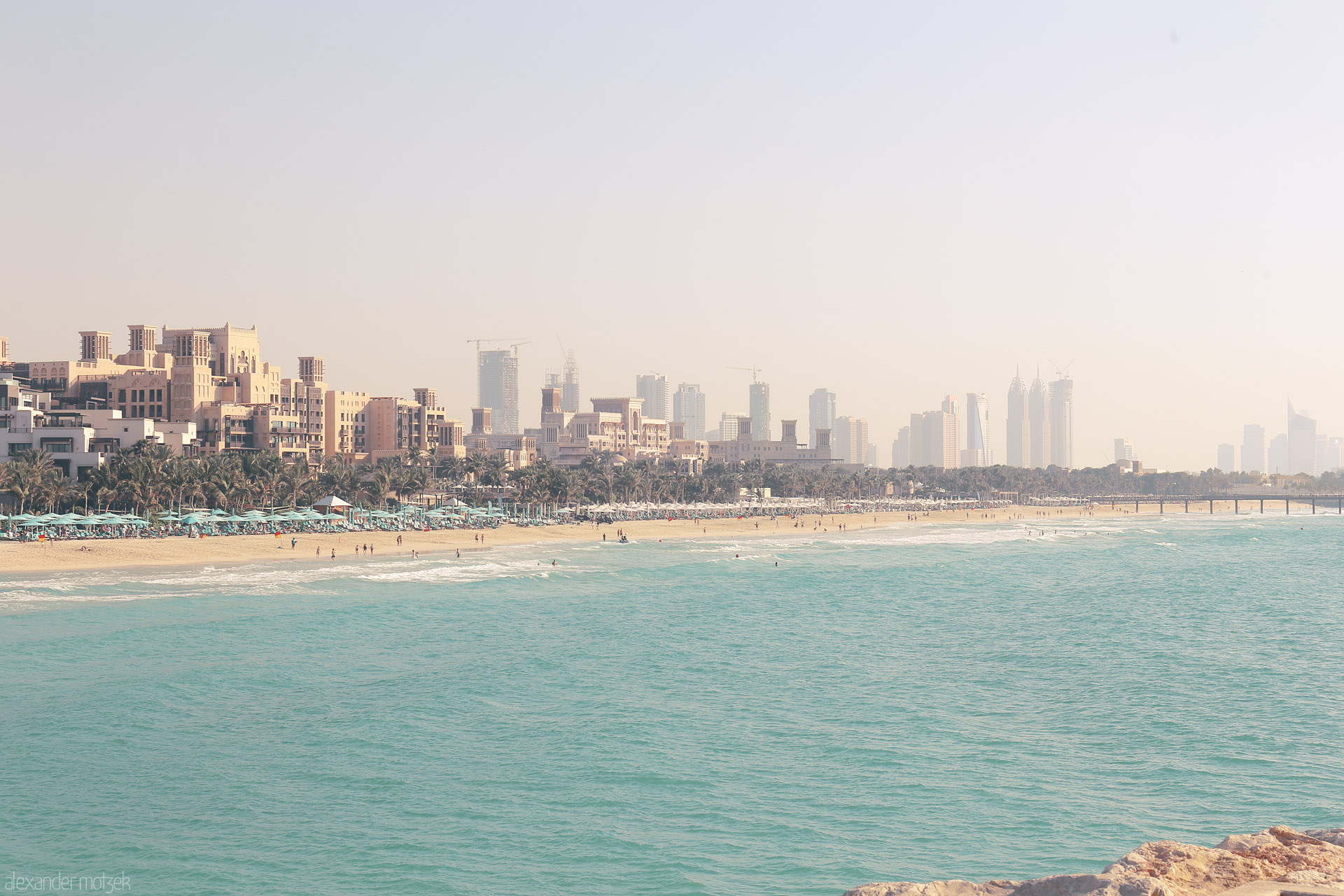 Habibi Shores Foto von Golden sands meet Arabian architecture, as Dubai’s skyline rises through the morning haze at Jumeirah Beach.