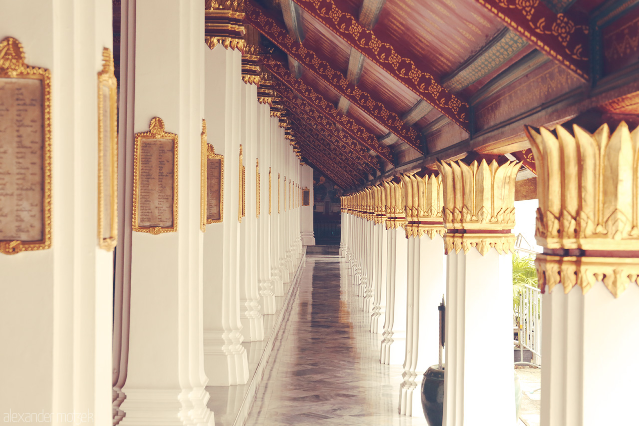Silent Majesty Foto von Golden-capped columns line a serene corridor at Phra Borom Maha Ratchawang, capturing Bangkok's architectural elegance.