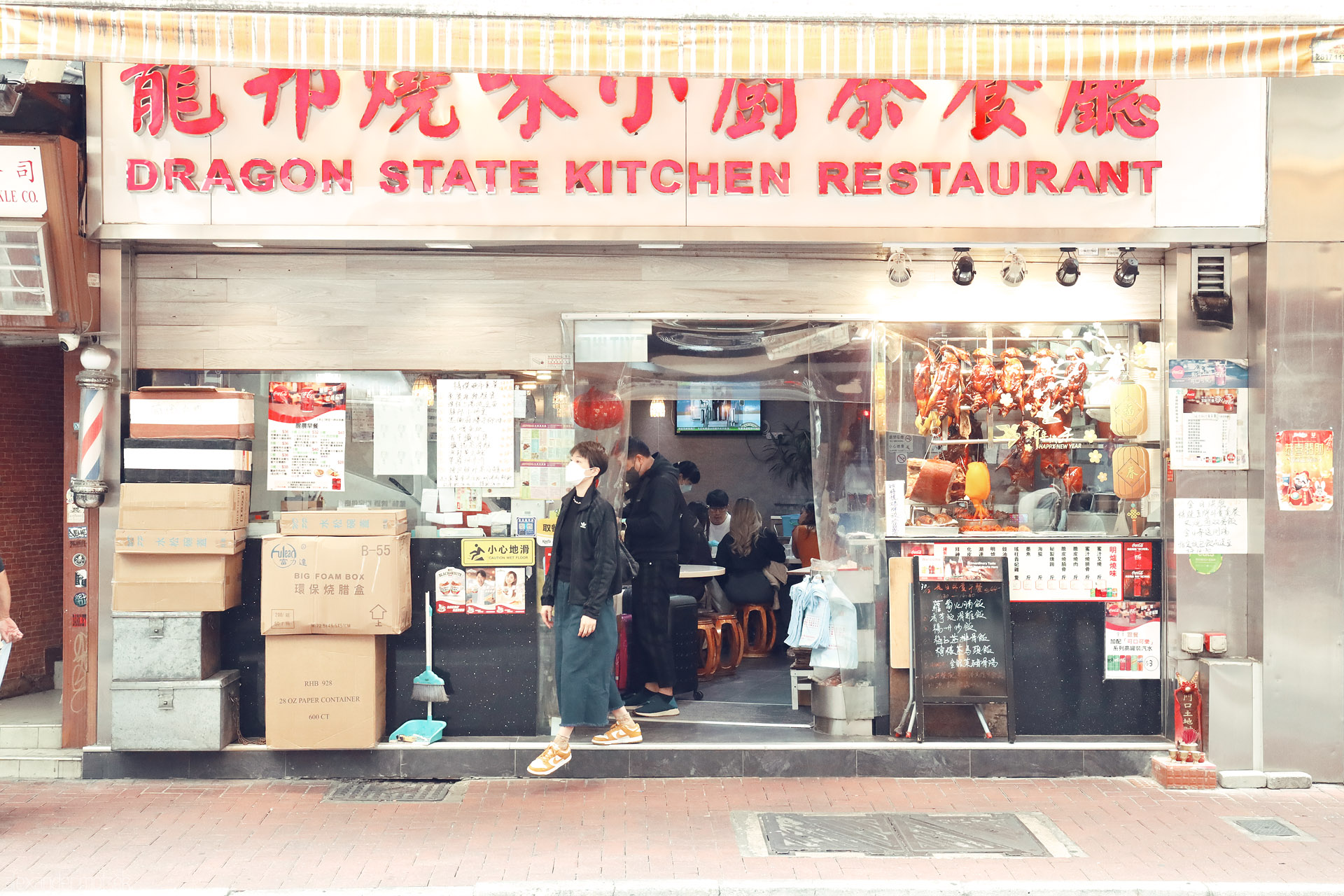 Foto von Siu mei roast meats hang behind glass at Dragon State Kitchen Restaurant on a busy Hong Kong Island street, Hong Kong.