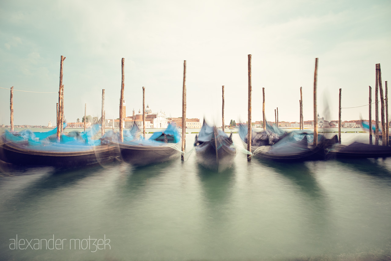 Gondole Whisper Foto von Long exposure of serene gondolas bobbing on the tranquil waters against a historic Venetian backdrop.