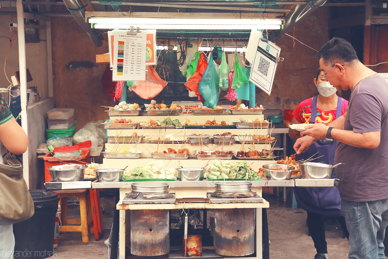 Penang Street Feast Foto von Discover the vibrant scene of Lok Lok street food in Penang, Malaysia, as locals savor skewered delights from bubbling pots.