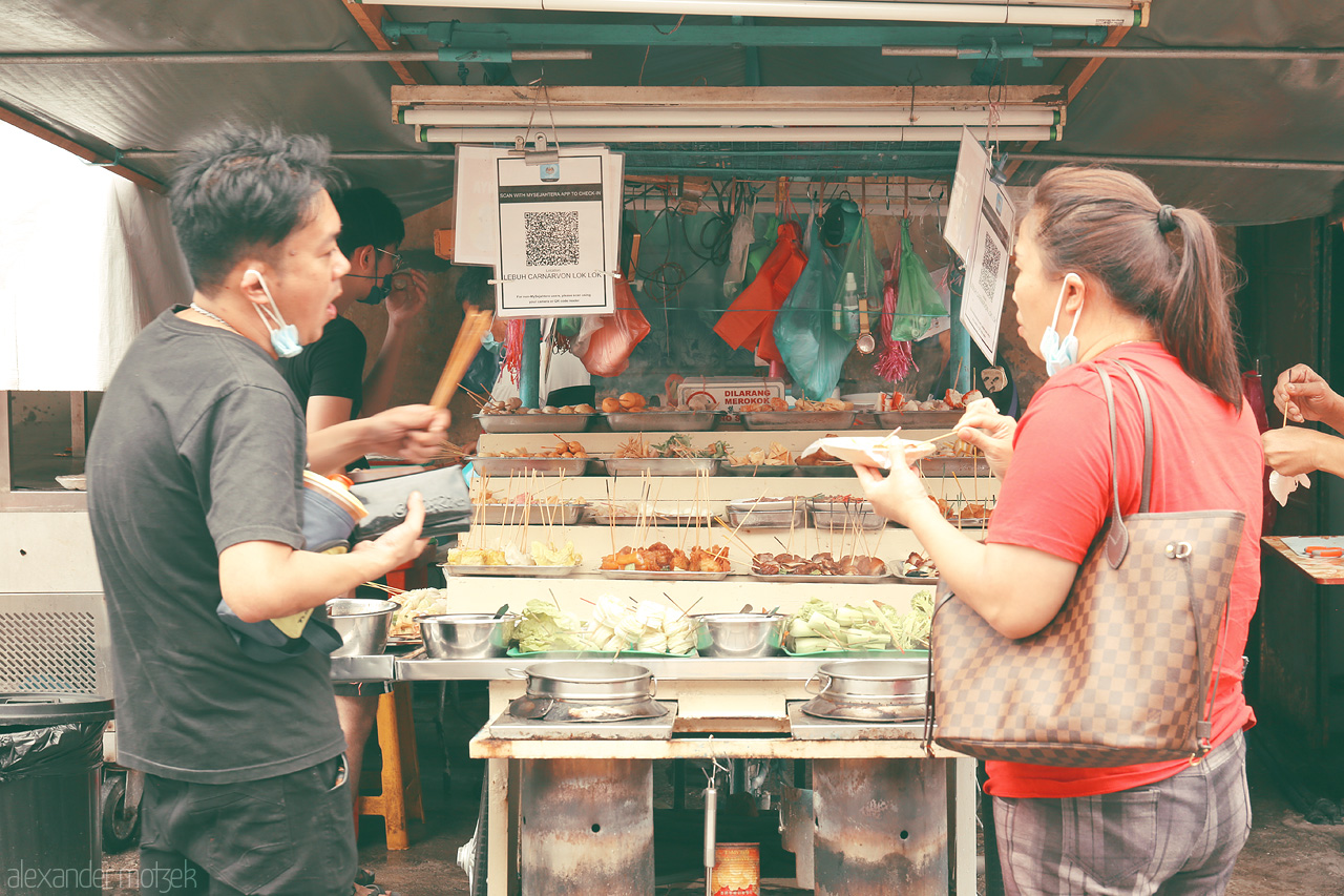 Lorong Foodsymphony Foto von Vibrant street food stall in Penang, Malaysia, with locals indulging in diverse flavors. A culinary journey through the heart of Lorong's bustling lanes.