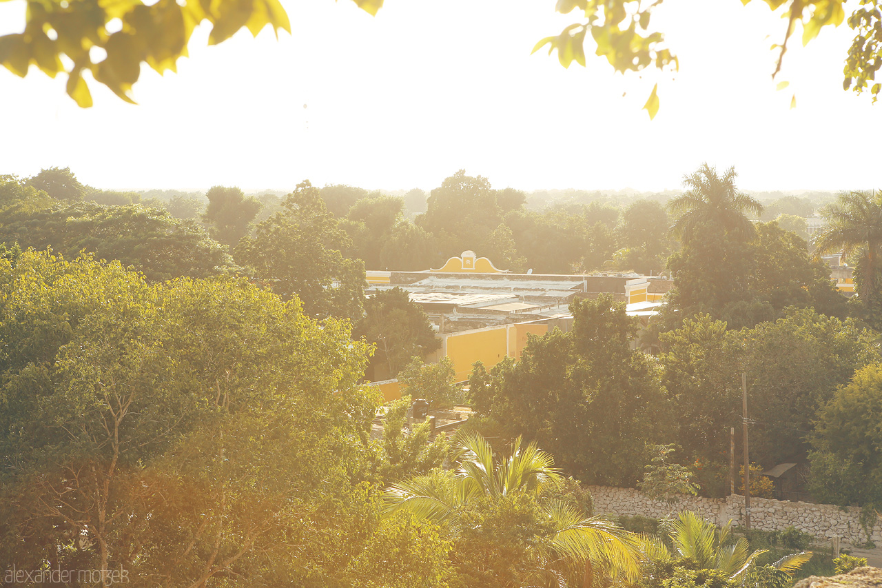 Foto von A golden sunset illuminates the lush greenery and yellow buildings of Izamal, the Yellow City of Yucatán.