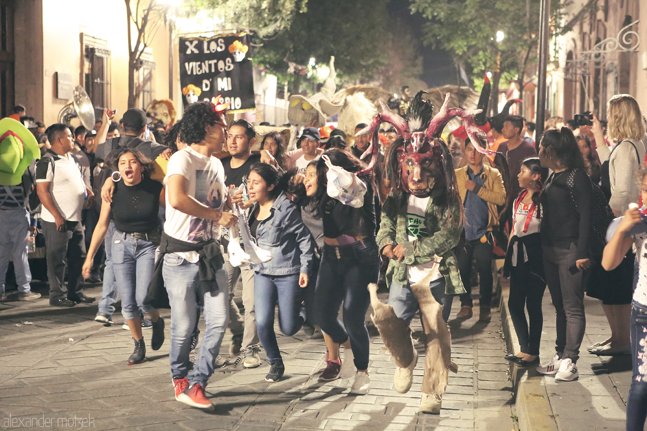 Fiesta Dia de Los Muertos Foto von Energetic street celebration at night in Oaxaca de Juárez, with vibrant local costumes and joyful crowd for the dia de los muertos.