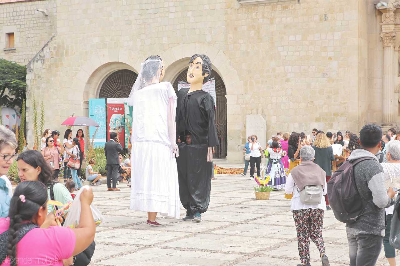 Foto von Giant puppets tower over a vibrant Oaxaca street scene, showcasing Mexico’s rich cultural tapestry.