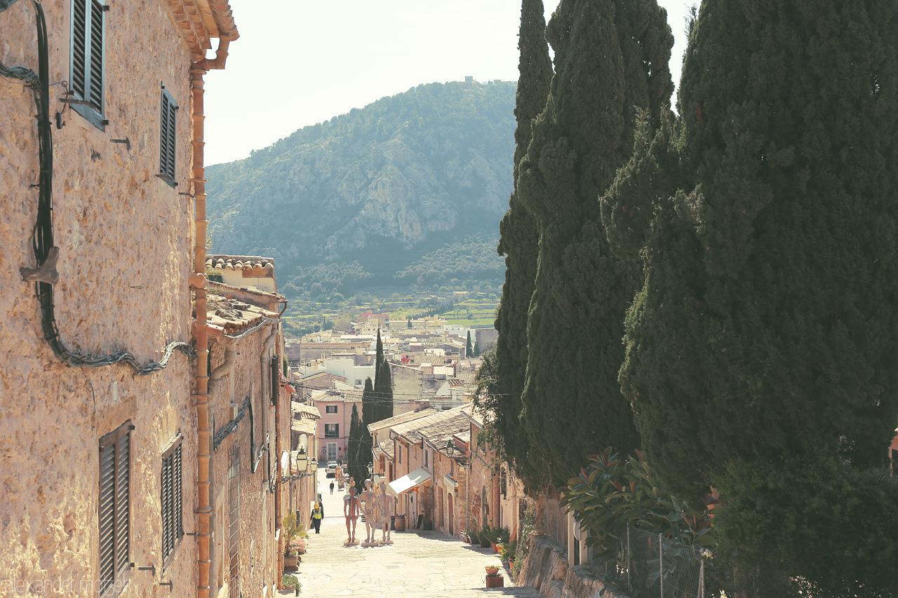 Foto von Old-town Pollença bathed in warm sunlight, with the Tramuntana in the distance.