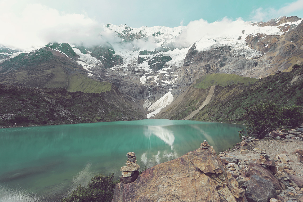 Foto von Am Gletschersee des Humantay auf dem Salkantay Trek in Peru mit kleinem Steinhaufen im Vordergrund