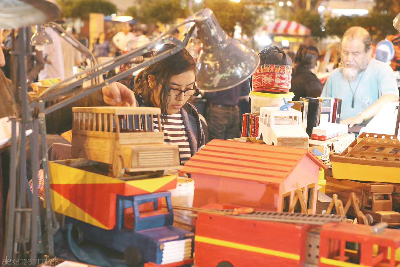 Foto von Frau kauft Spielzeug auf dem Nachtmarkt auf dem Parque John F. Kennedy in Lima