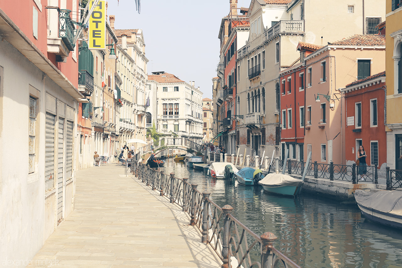 Serenissima Suggestioni Foto von Quaint Venetian canal lined with pastel facades under a serene sky, a glimpse into the serene beauty of Venice.