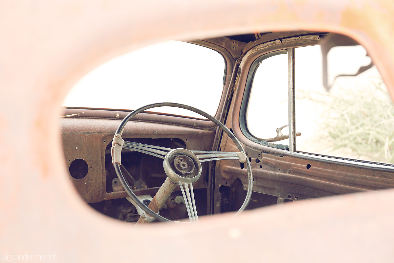 Solitaire's Forgotten Wheel Foto von Rustic car interior glimpsing Namibia's past, in desolate Solitaire.