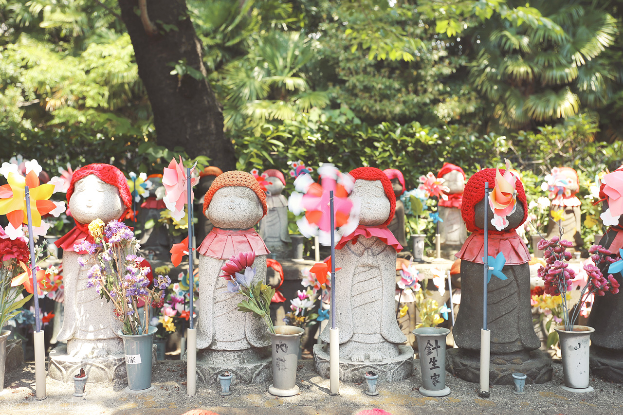 Jizo Foto von Small statues wearing cute little red hats in honor of the children