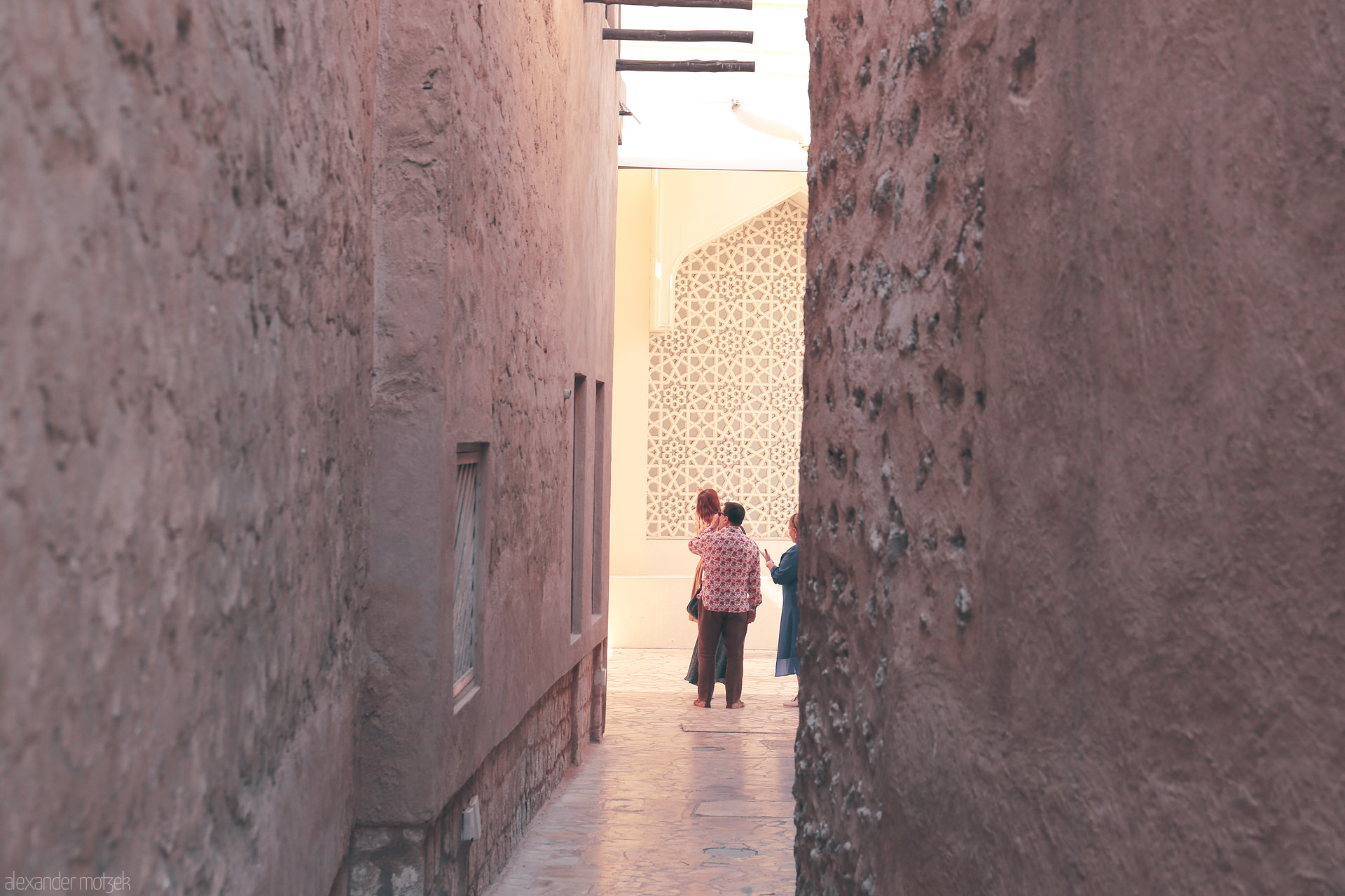 Alleyway to Al Seef Foto von Sunlit alleys of Al Fahidi, Dubai—earthy walls, mashrabiya patterns, and wanderers caught in heritage's quiet embrace.
