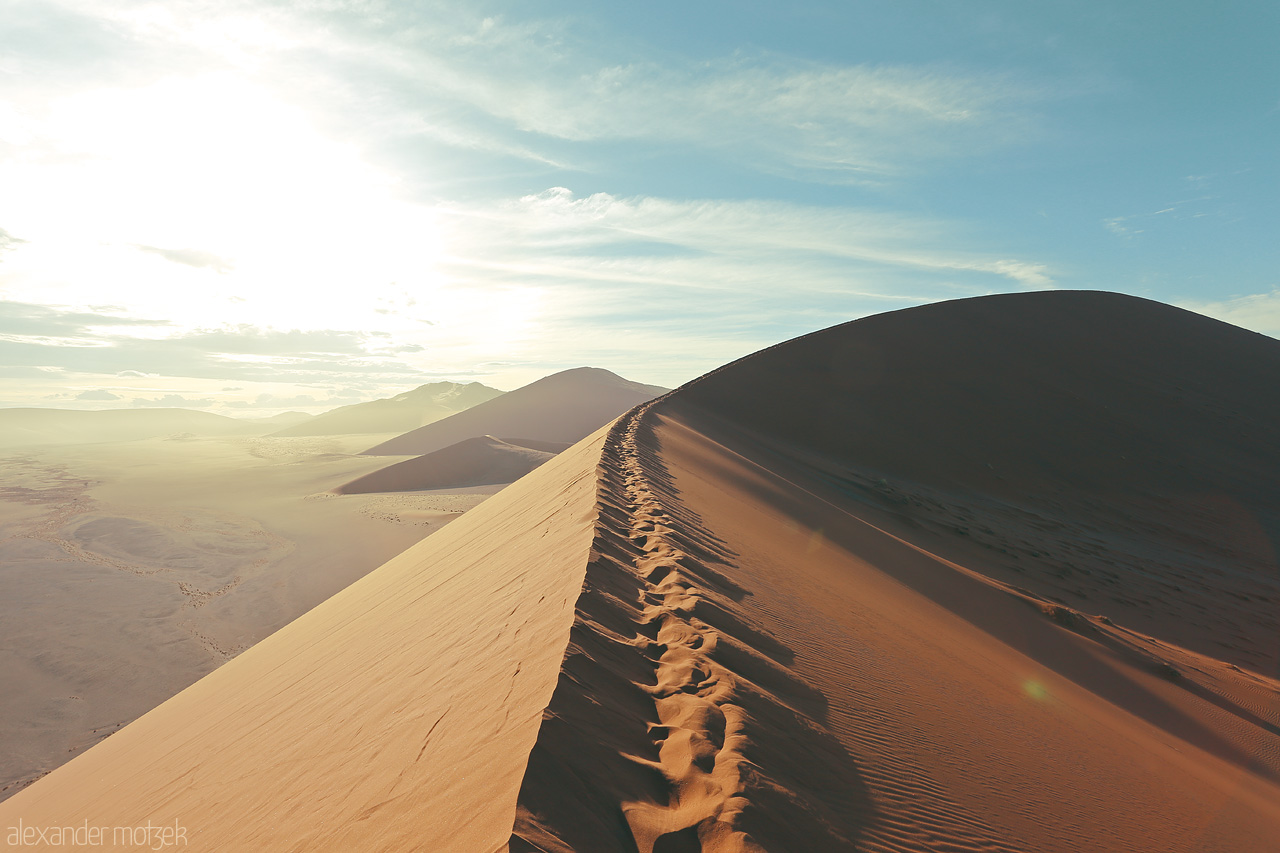 Namib's Whispering Dunes Foto von Sunrise over Sossusvlei's sand peaks, painting a serene Namibian panorama.